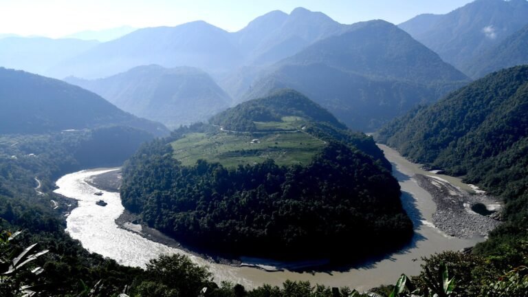 A circular river is carved into the middle of a mountainous landscape.